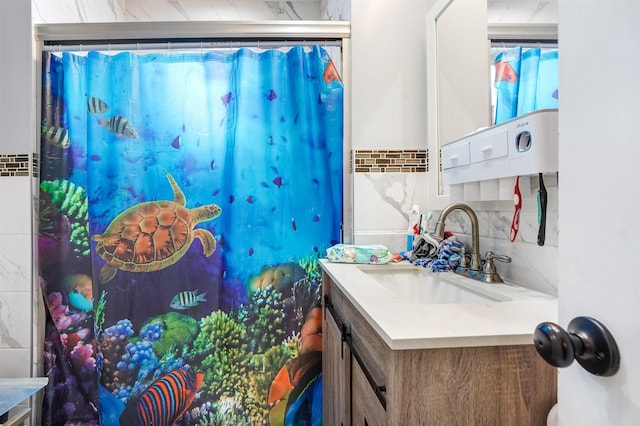 bathroom with backsplash, curtained shower, and vanity