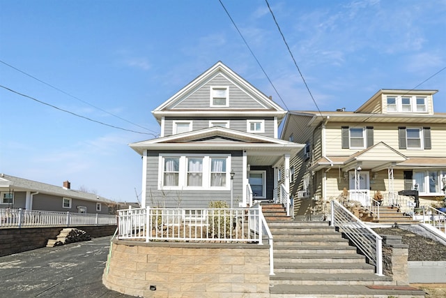 view of front of home with cooling unit, covered porch, and fence