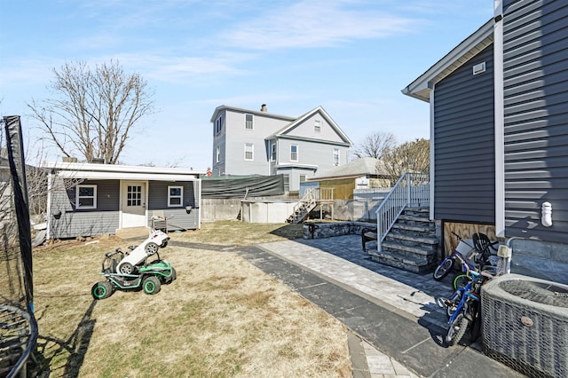 view of yard with central AC and fence