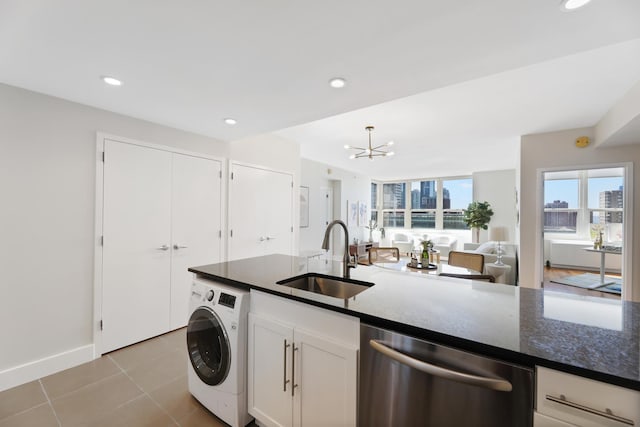 kitchen featuring dishwasher, an inviting chandelier, white cabinets, sink, and washer / clothes dryer