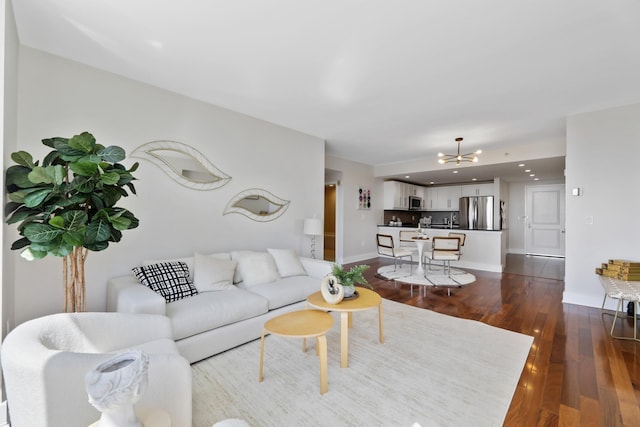 living room featuring dark wood-type flooring and a notable chandelier