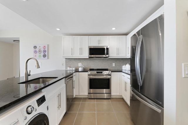 kitchen featuring sink, light tile patterned floors, washer / clothes dryer, white cabinets, and appliances with stainless steel finishes