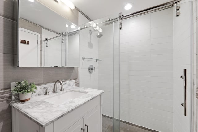 bathroom featuring vanity and a shower with shower door