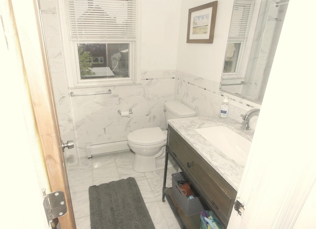 bathroom with marble look tile flooring, tile walls, toilet, vanity, and a wainscoted wall