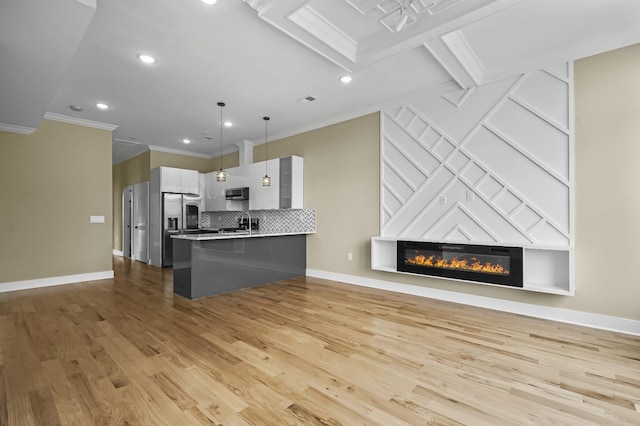 kitchen with white cabinetry, kitchen peninsula, stainless steel appliances, a breakfast bar, and pendant lighting