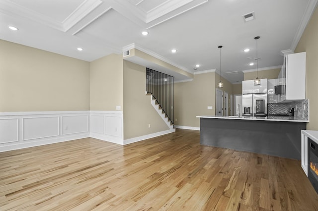 kitchen featuring hanging light fixtures, stainless steel refrigerator with ice dispenser, decorative backsplash, light hardwood / wood-style floors, and white cabinetry