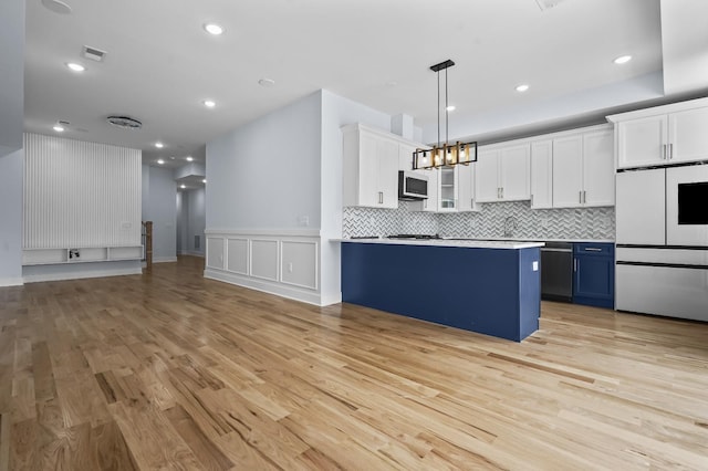 kitchen with refrigerator, white cabinetry, light hardwood / wood-style flooring, decorative light fixtures, and blue cabinets