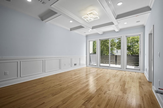 spare room featuring ornamental molding, beamed ceiling, coffered ceiling, and light hardwood / wood-style flooring