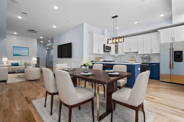 dining room with light hardwood / wood-style floors and a chandelier