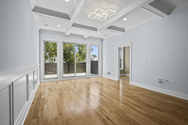 unfurnished living room featuring coffered ceiling, ornamental molding, light wood-type flooring, and beam ceiling