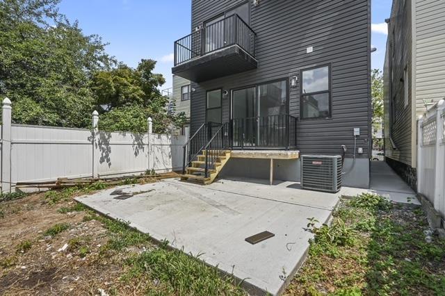 rear view of property with a patio area, central AC, and a balcony