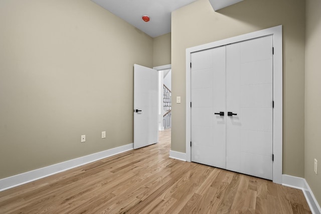 unfurnished bedroom featuring light hardwood / wood-style flooring and a closet