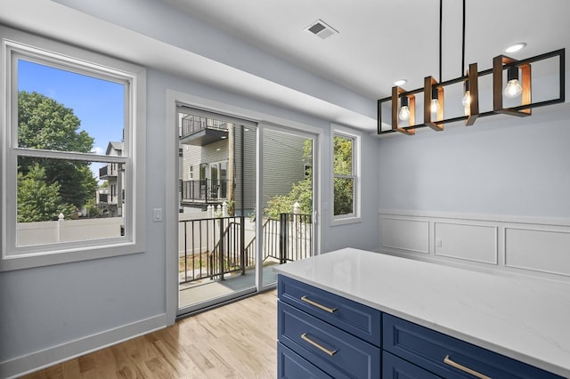 doorway to outside with a wealth of natural light and light hardwood / wood-style flooring