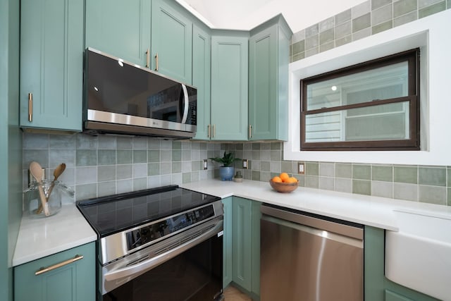 247 Harrison Ave Unit 2, Jersey City, NJ 07304 - kitchen with appliances with stainless steel finishes, tasteful backsplash, light countertops, and green cabinetry