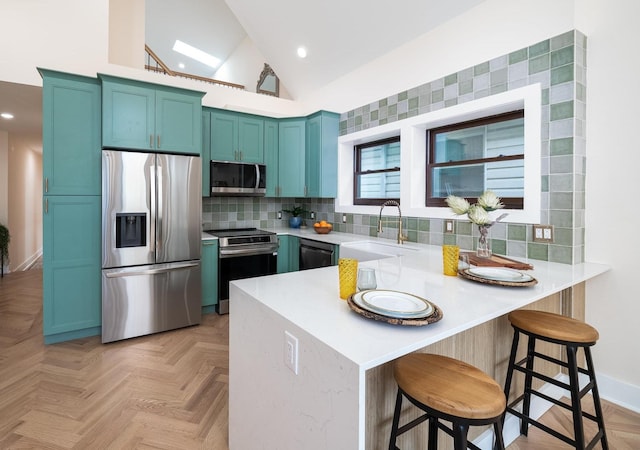 247 Harrison Ave Unit 2, Jersey City, NJ 07304 - kitchen featuring stainless steel appliances, a sink, a peninsula, lofted ceiling, and light countertops