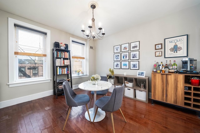 dining room with baseboards, a chandelier, and dark wood-type flooring