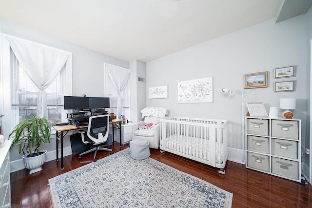 bedroom with wood finished floors, visible vents, and baseboards