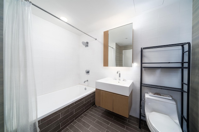 full bathroom featuring vanity, toilet, and tile walls