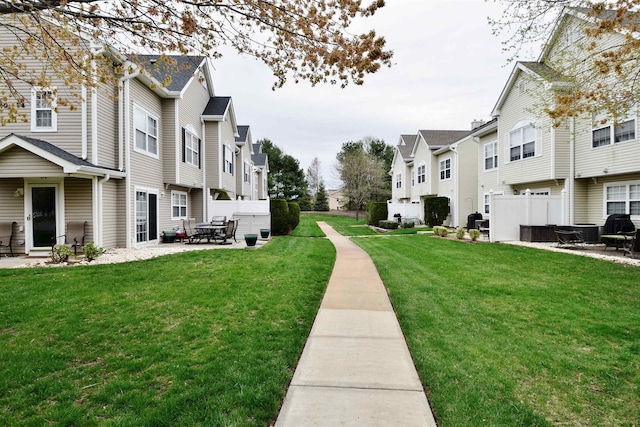 surrounding community with a lawn, a patio, and a residential view
