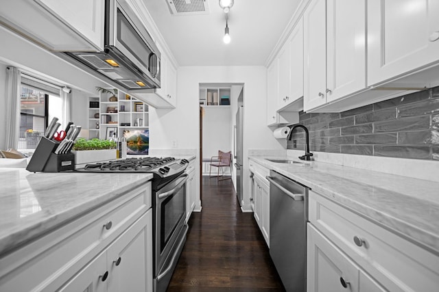 222 Clinton St Unit 23, Hoboken, NJ 07030 - kitchen with appliances with stainless steel finishes, white cabinetry, tasteful backsplash, and light stone countertops