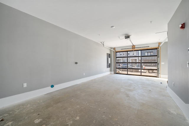 garage with a garage door opener, electric panel, and baseboards