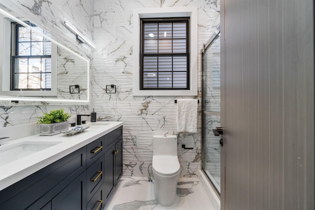 full bath with marble finish floor, a sink, toilet, and a shower stall