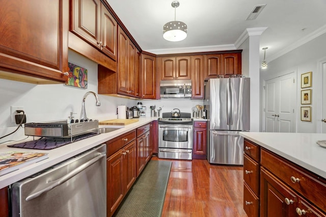 20 Avenue At Port Imperial Unit 425, West New York, NJ 07093 - kitchen featuring appliances with stainless steel finishes, light countertops, dark wood-style floors, crown molding, and pendant lighting