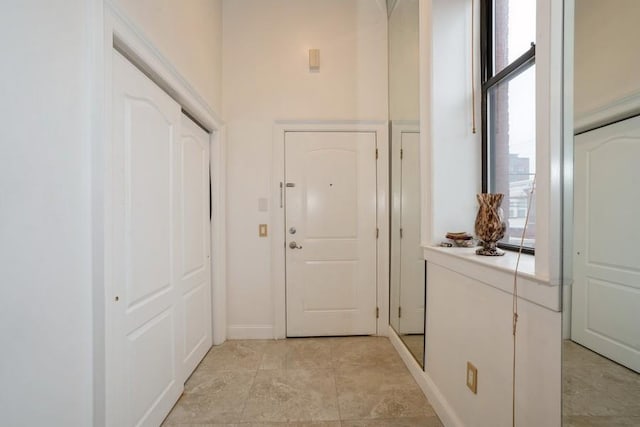 doorway featuring healthy amount of natural light and baseboards
