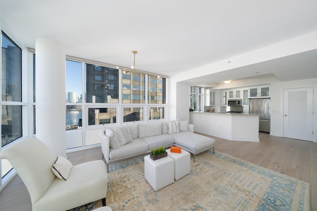 living room with light hardwood / wood-style floors and a wall of windows