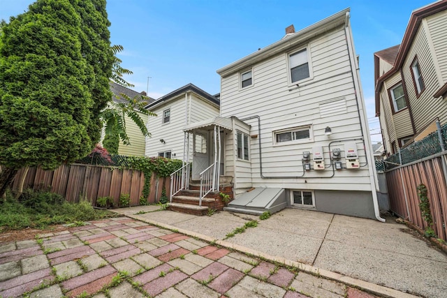 31 E 32nd St, Bayonne, NJ 07002 - rear view of property featuring a fenced backyard, a chimney, and a patio