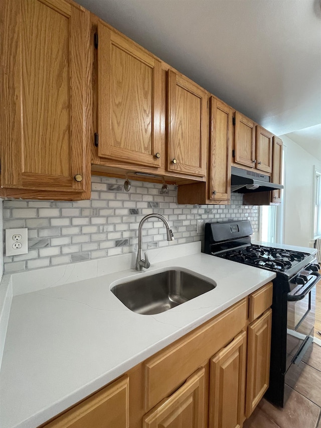 31 E 32nd St, Bayonne, NJ 07002 - kitchen featuring black gas stove, a sink, under cabinet range hood, light countertops, and decorative backsplash