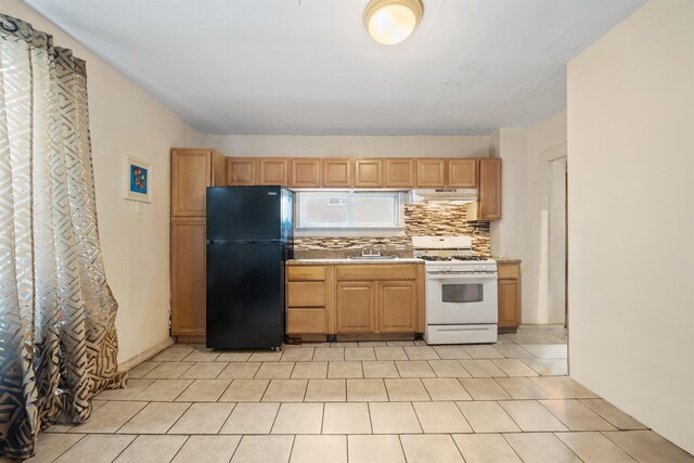 31 E 32nd St, Bayonne, NJ 07002 - kitchen with freestanding refrigerator, white gas range oven, a sink, under cabinet range hood, and backsplash