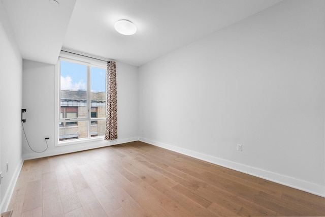 empty room featuring baseboards and wood finished floors