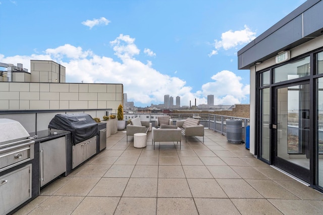 view of patio featuring a view of city, exterior kitchen, and grilling area