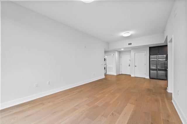 unfurnished bedroom with multiple closets, visible vents, light wood-style floors, freestanding refrigerator, and baseboards