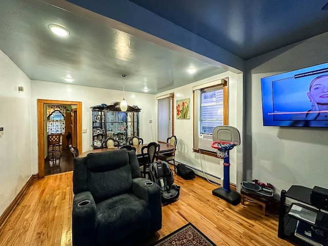 living room featuring wood-type flooring and a baseboard heating unit