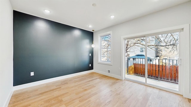 spare room with light wood-style floors, recessed lighting, visible vents, and baseboards