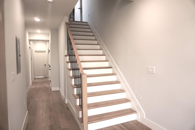 stairway featuring wood finished floors and baseboards