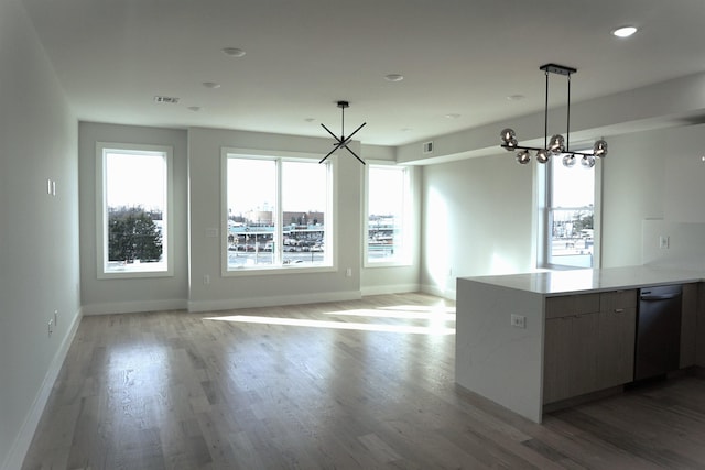 kitchen with open floor plan, light countertops, light wood finished floors, modern cabinets, and decorative light fixtures