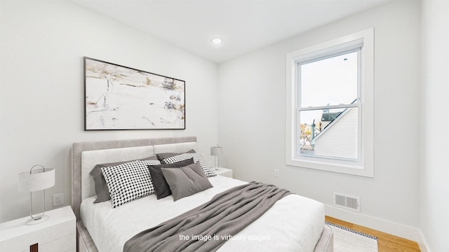 bedroom with baseboards, visible vents, wood finished floors, and recessed lighting