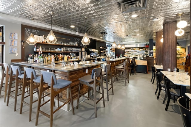 bar featuring an ornate ceiling, finished concrete floors, wet bar, and visible vents