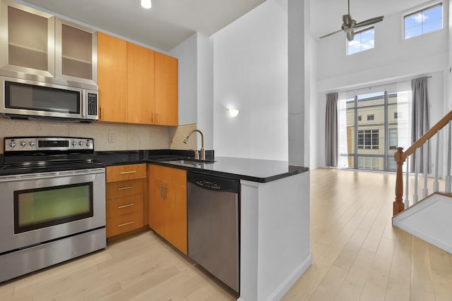 26 Ave At Port Imperial Unit 440, West New York, NJ 07093 - kitchen featuring stainless steel appliances, light wood finished floors, dark countertops, backsplash, and ceiling fan
