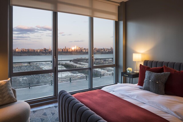 bedroom with a water view and a view of city