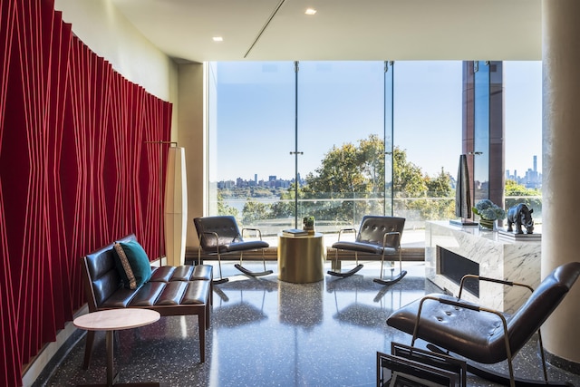 living area featuring a wall of windows, a view of city, and speckled floor