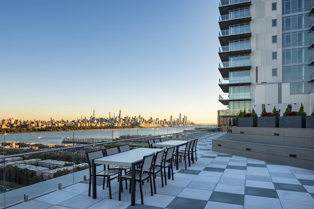 view of patio featuring a water view and outdoor dining space