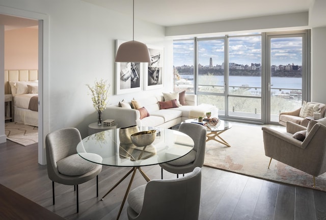 dining area with a water view, wood finished floors, and a view of city