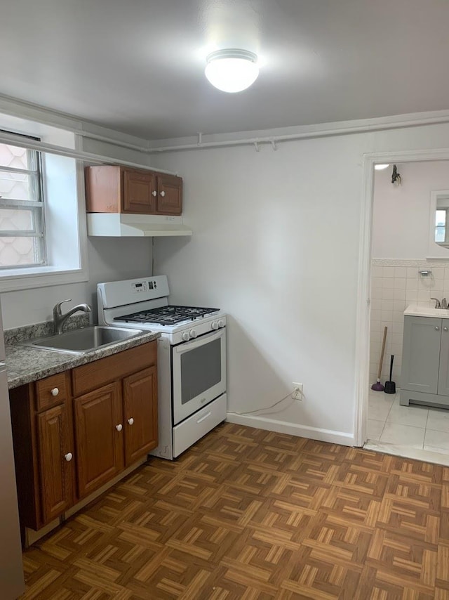 1518 38th St, North Bergen, NJ 07047 - kitchen featuring white range with gas cooktop, a sink, under cabinet range hood, and brown cabinetry