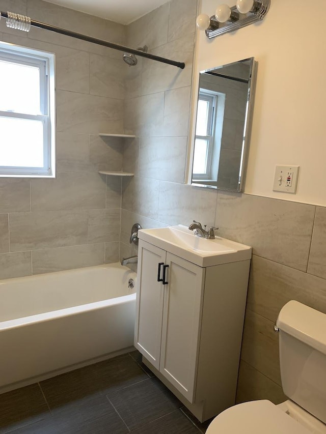 1518 38th St, North Bergen, NJ 07047 - bathroom featuring tile walls, toilet, vanity, bathtub / shower combination, and healthy amount of natural light