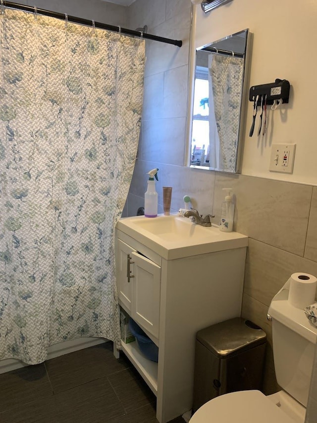 1518 38th St, North Bergen, NJ 07047 - bathroom with tile walls, toilet, vanity, and tile patterned flooring