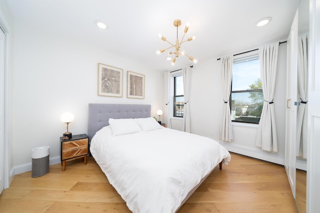 bedroom with recessed lighting, an inviting chandelier, and light wood-style flooring